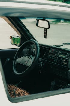 Explore the vintage aesthetic of a classic car interior with detailed dashboard and steering wheel.