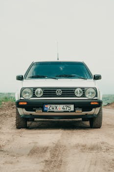 Front view of a classic Volkswagen car parked on a dirt road in Moldova, showcasing vintage design.