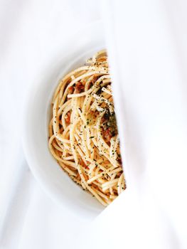 Simple and elegant spaghetti dish with herbs, styled in a minimalist setting. Perfect for Italian cuisine lovers.