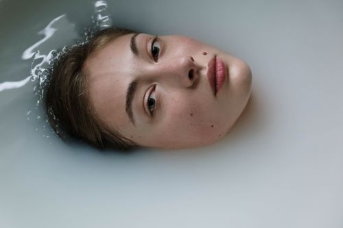 Free Close-up of a woman's face partially submerged, evoking a serene and contemplative mood. Stock Photo