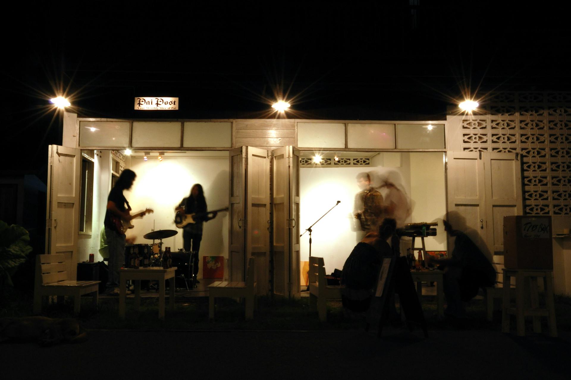 Live band performing at night in an outdoor setting, creating a vibrant musical ambiance.