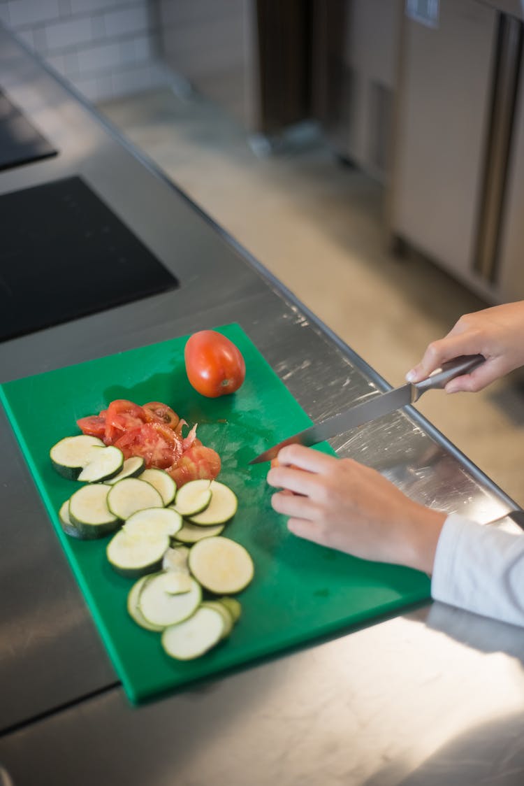 A Person Slicing A Tomato