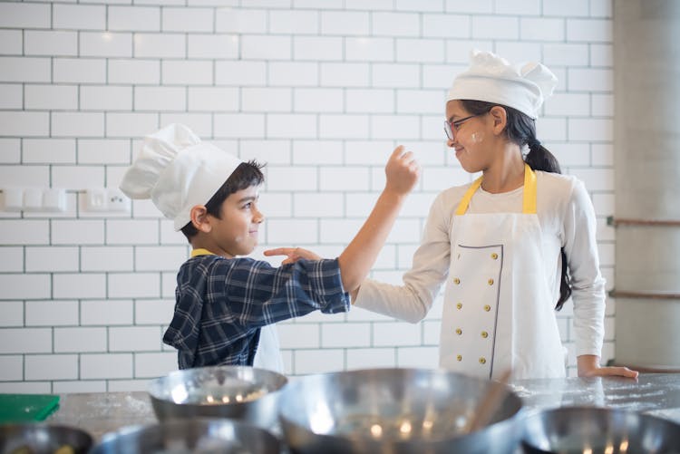 Kids With Chef Hats Playing In Kitchen