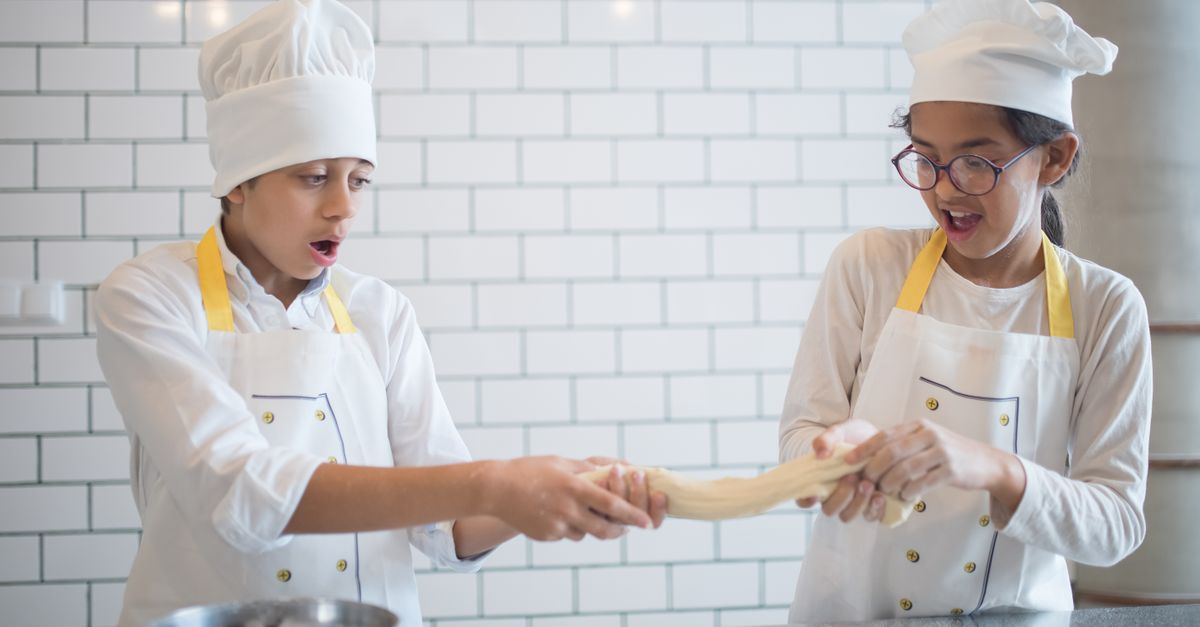 Chef Stretch Kids Wearing Chef's Uniform while Stretching the Dough they are Holding ...