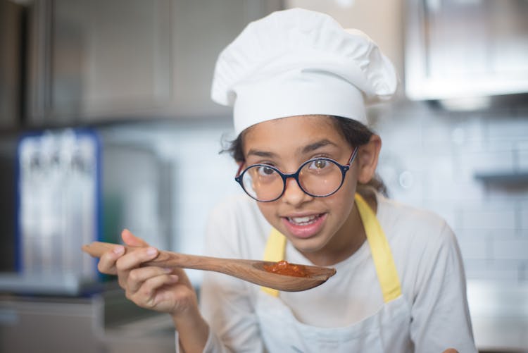 A Young Girl Holding A Wooden Spoon