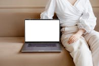 Person in White Long Sleeve Shirt and White Pants Sitting on White Chair