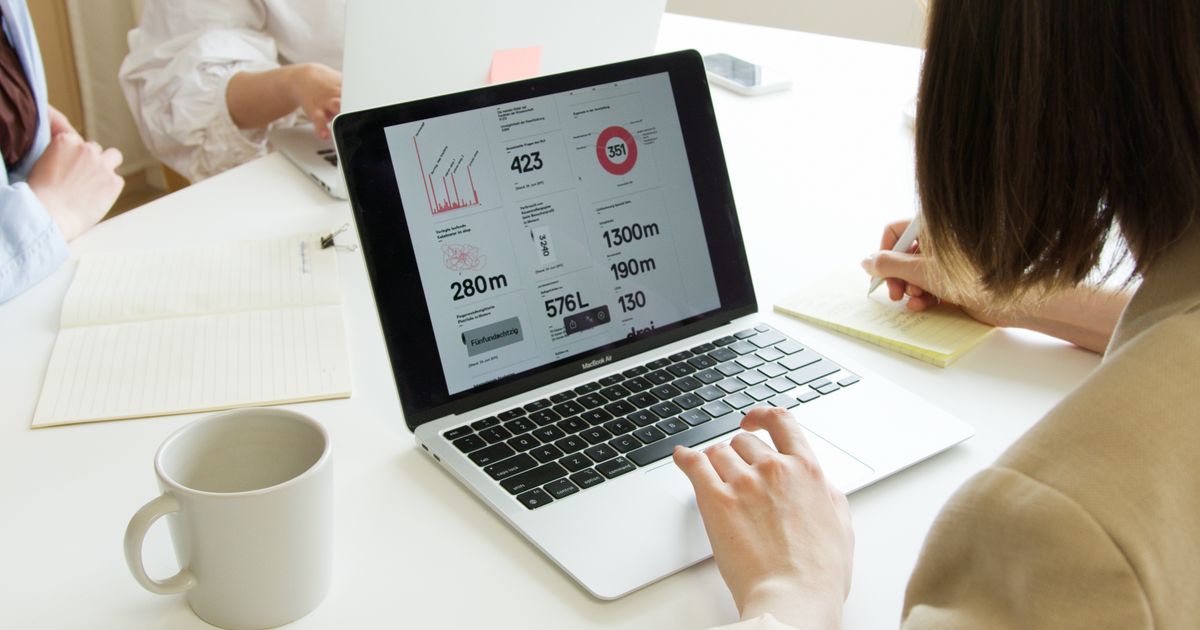 Courtière analysant un tableau de bord de performance sur un ordinateur portable