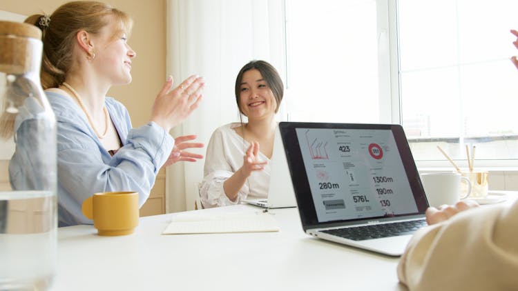 Employees Sitting On A Chair While Clapping Their Hands