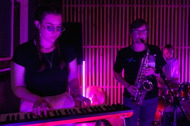 A Woman Playing An Electronic Keyboard In A Band