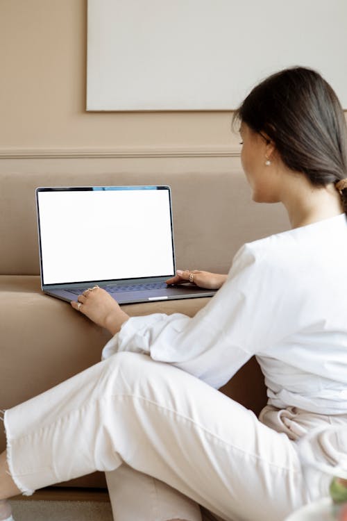 Free Woman in White Long Sleeve Shirt Typing on Her Laptop Stock Photo