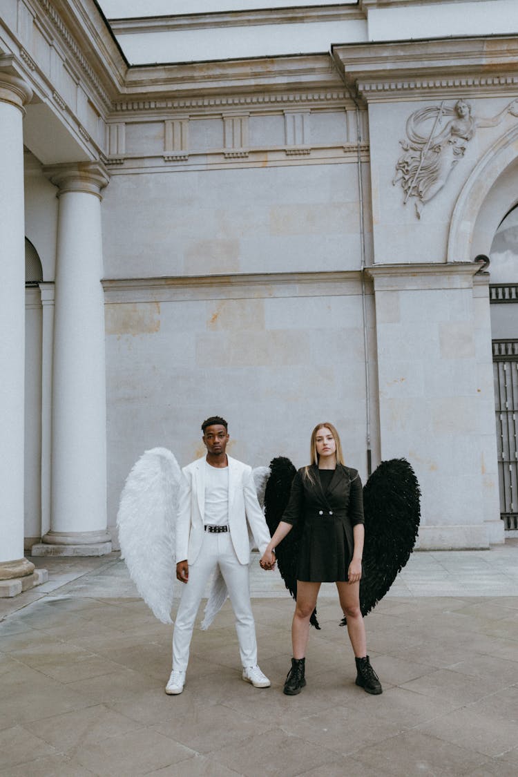 A Man And Woman Wearing Angel Costumes