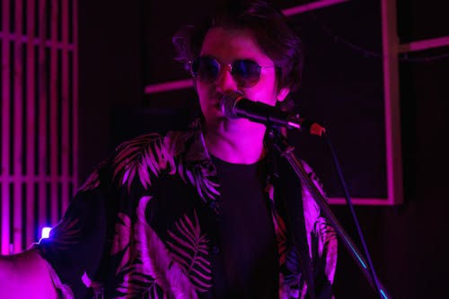 A Man wearing Sunglasses While Singing 