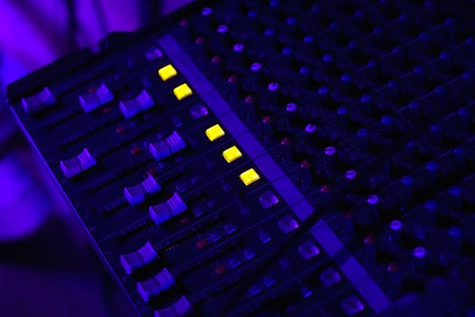 Detailed image of an illuminated audio mixing panel with glowing yellow lights, perfect for tech visuals.