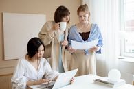 Woman in White Long Sleeve Shirt Holding White Ceramic Mug