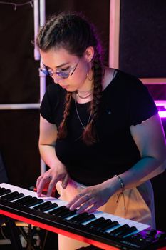 Woman in Black Shirt and Black Framed Eyeglasses Playing Piano