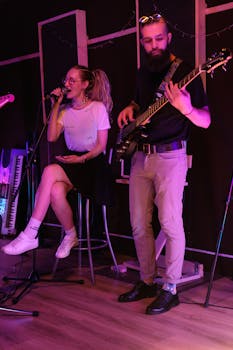 Captured a lively performance of a singing duo with guitar in an intimate indoor setting.