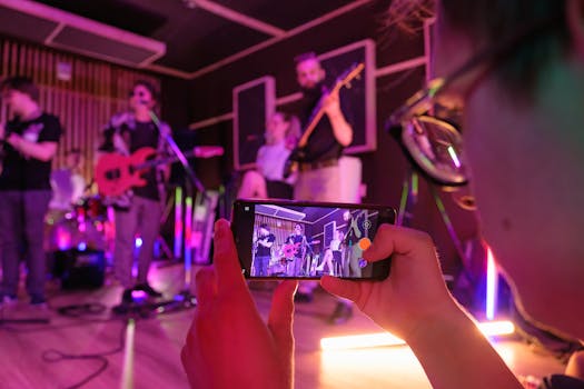 A dynamic band performs live in a music studio, captured on a smartphone.