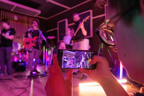 Free A dynamic band performs live in a music studio, captured on a smartphone. Stock Photo