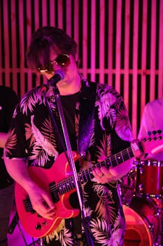 Vibrant live band performance featuring a guitarist singing into a microphone with neon lights.