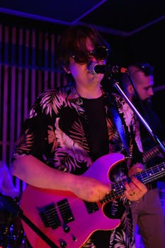 Musical performance featuring a guitarist and singer in a vibrant indoor setting.