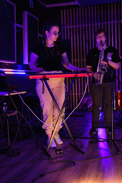 Woman in Black Shirt Playing Electric Keyboard