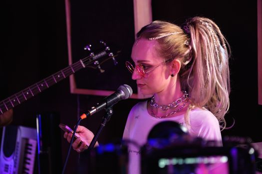 Woman in White Shirt Playing Guitar