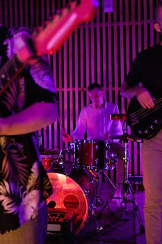 Vibrant live band performance featuring a drummer in an indoor setting with colorful lighting.