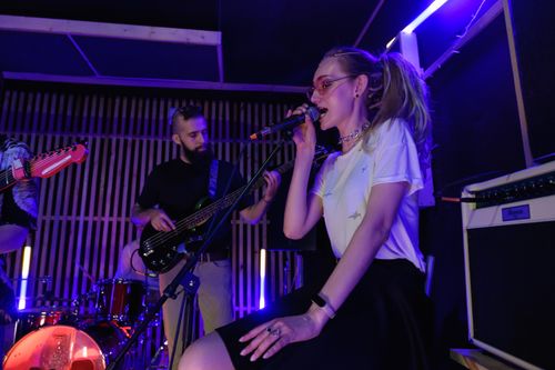 Free Dynamic live performance of a band with vibrant lighting and engaging musicians. Stock Photo