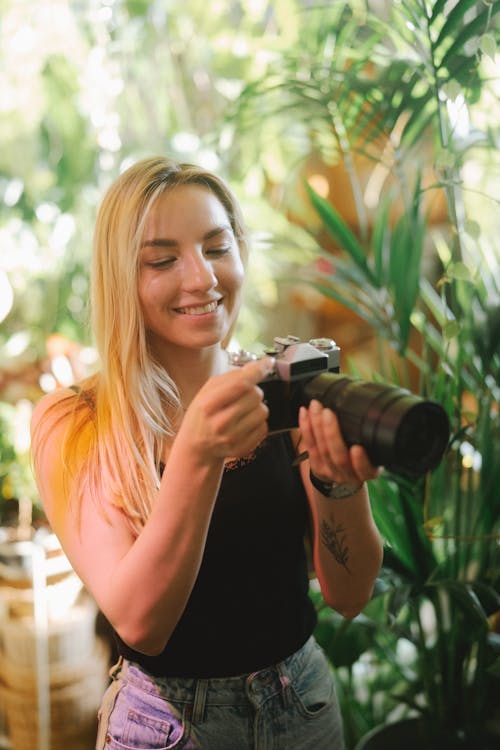 A Woman in Spaghetti Strap Top Holding DSLR Camera