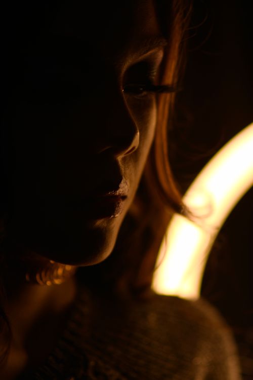 Free Dark silhouette of a woman with mysterious light, creating dramatic shadows. Stock Photo