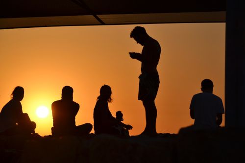 Free Silhouette of people at sunset creating a peaceful and contemplative scene. Stock Photo