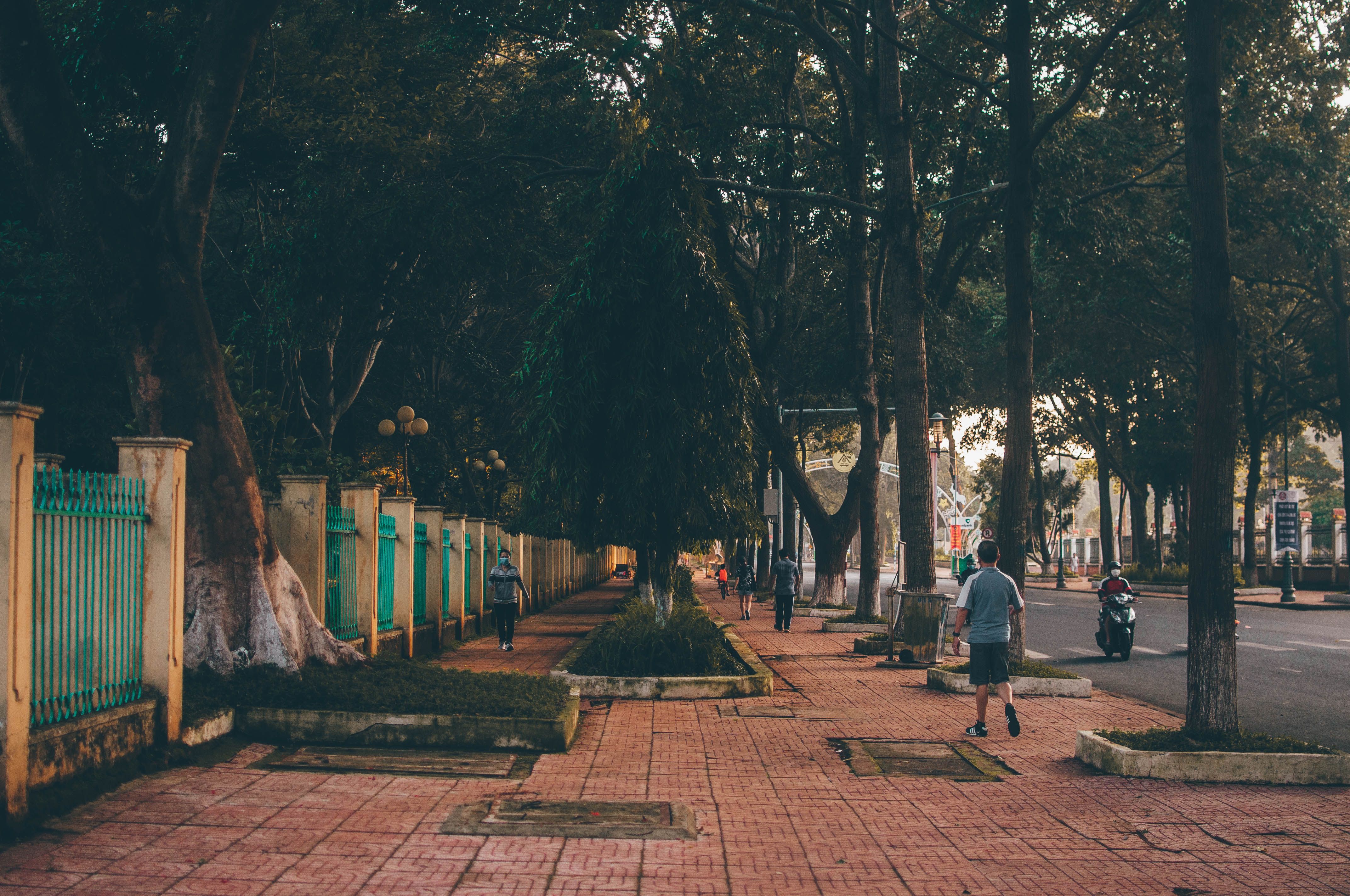 Tranquil street scene with people walking and scooters in Buon Ma Thuot, Vietnam.