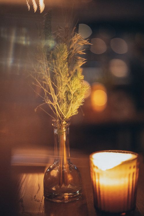 Free Warm candlelit ambiance featuring twigs in a glass bottle, perfect for cozy settings. Stock Photo