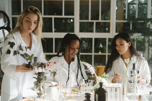 Free Three women scientists examining plants in a laboratory setting. Stock Photo