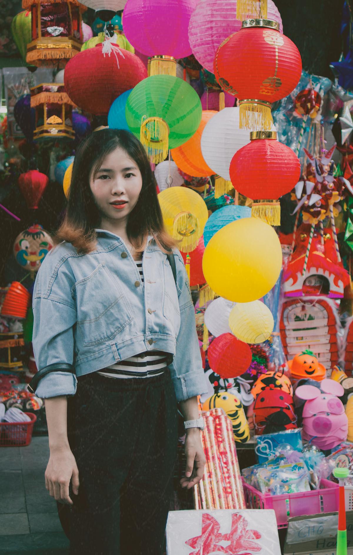 A matcha latte in a ceramic cup on a wooden table with a bamboo whisk beside it