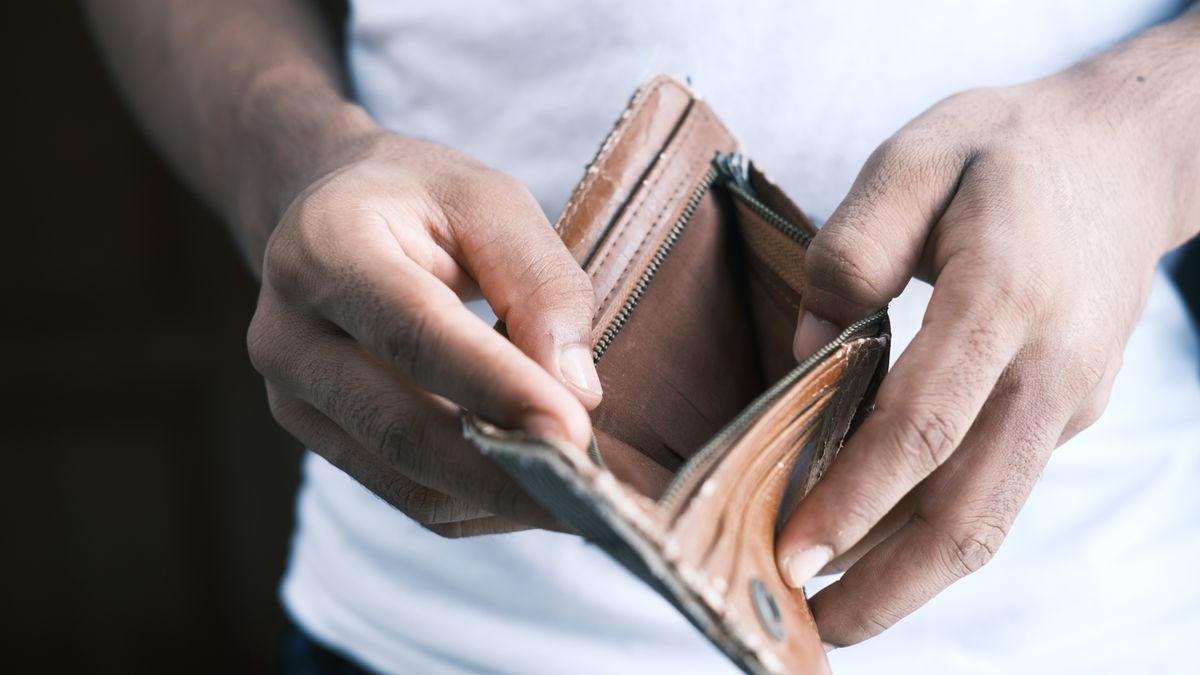 Close-up of hands holding an empty wallet, highlighting financial struggles and economic crisis.