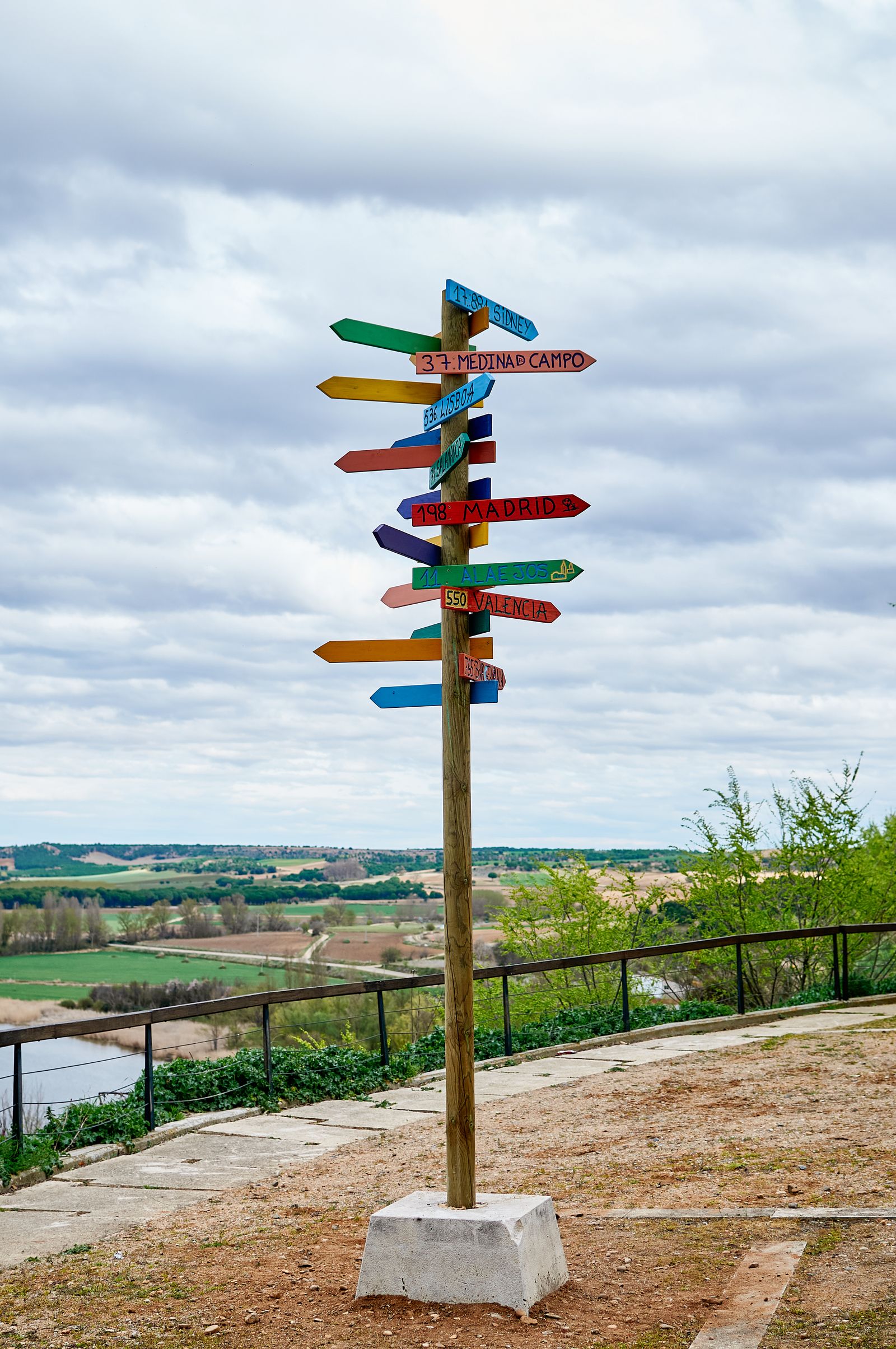 A wooden signpost in an open landscape pointing multiple directions
