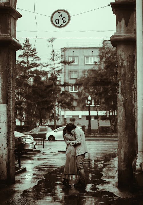 Grayscale Photo of Couple Kissing at the Alley