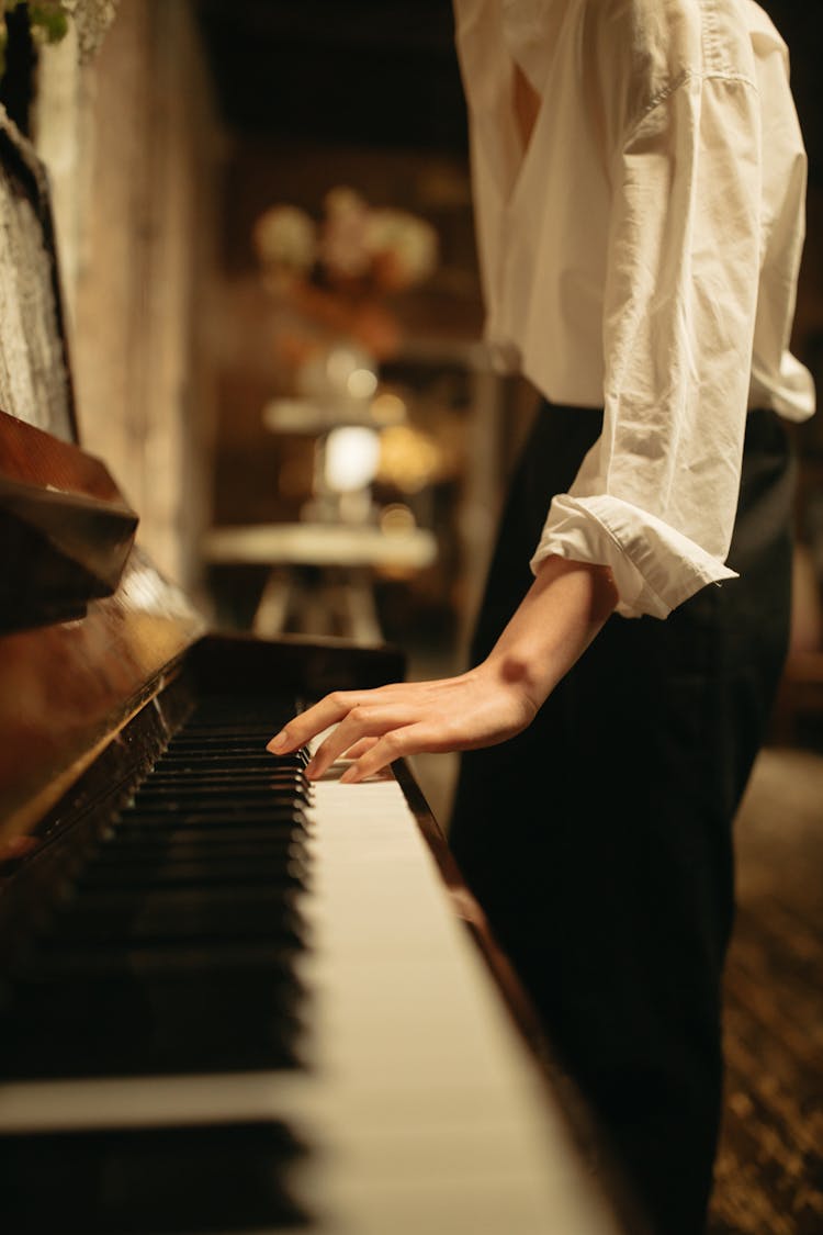 Person In White Long Sleeves Playing Piano