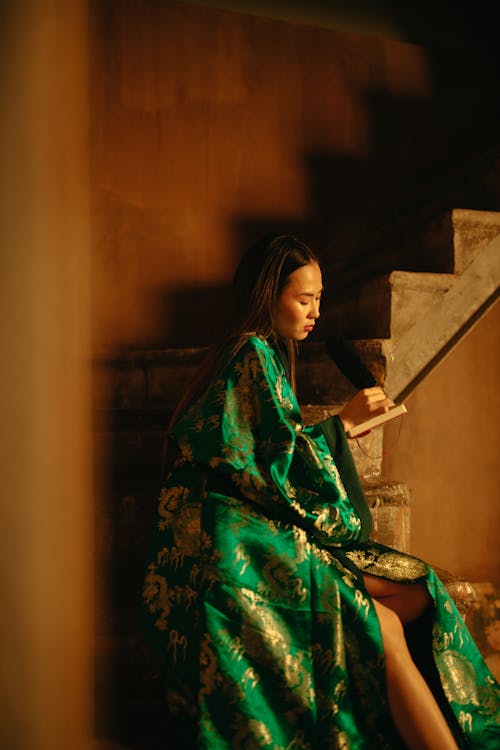 Free Woman in Green Kimono Sitting on Stairs Stock Photo