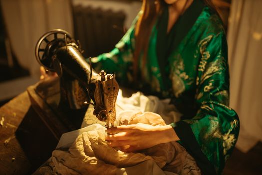 A fashion designer sewing with a vintage machine in a textile studio.