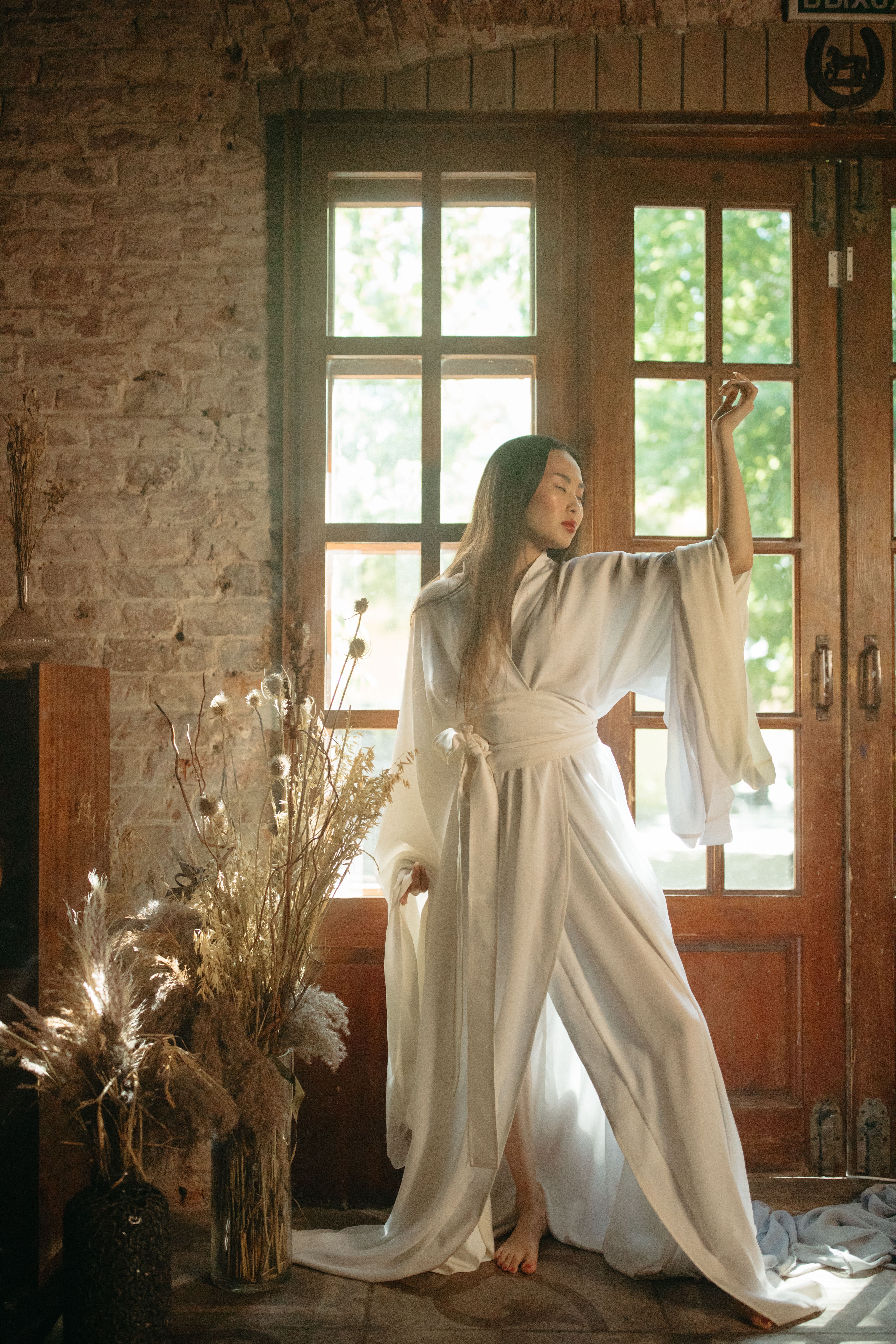 Woman in White Long Sleeve Dress Standing Near Wooden Door · Free Stock ...