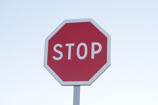 A clear image of a red stop sign with a white background, symbolizing caution.
