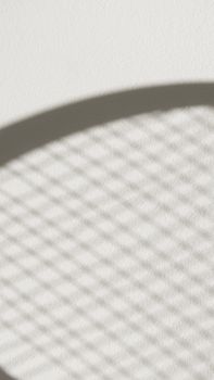 Abstract geometric shadow cast on a textured surface creating a minimalist and artistic pattern.