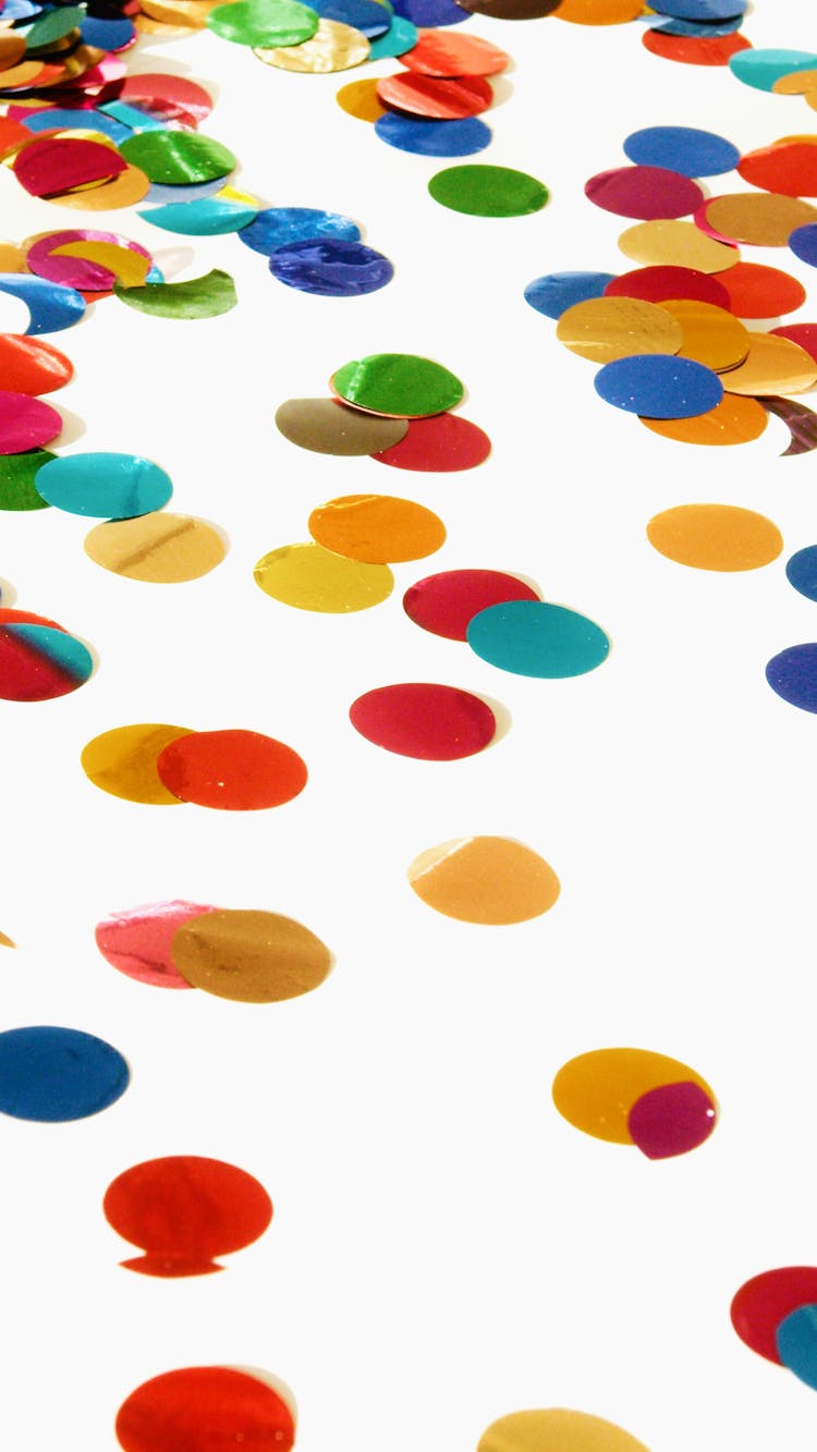 Different Colors Round Shaped Confetti On A White Surface