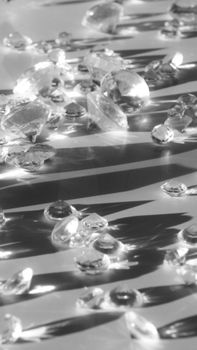 A collection of shining gemstones on a striped monochrome background.