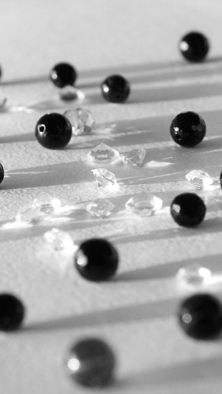 Black Round Beads And Crystals On White Surface