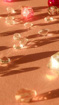 Sparkling diamonds casting shadows on a peach surface, highlighting luxury and elegance.