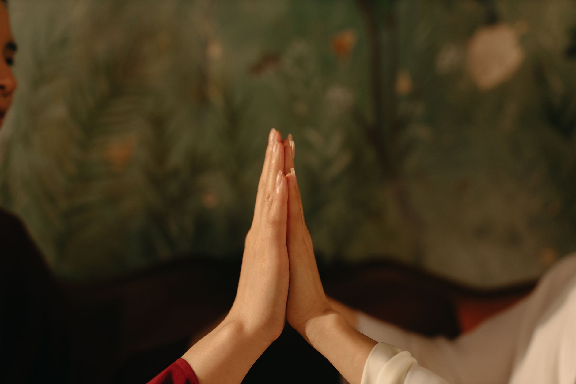 Two hands touching in calm setting symbolizing unity and connection.