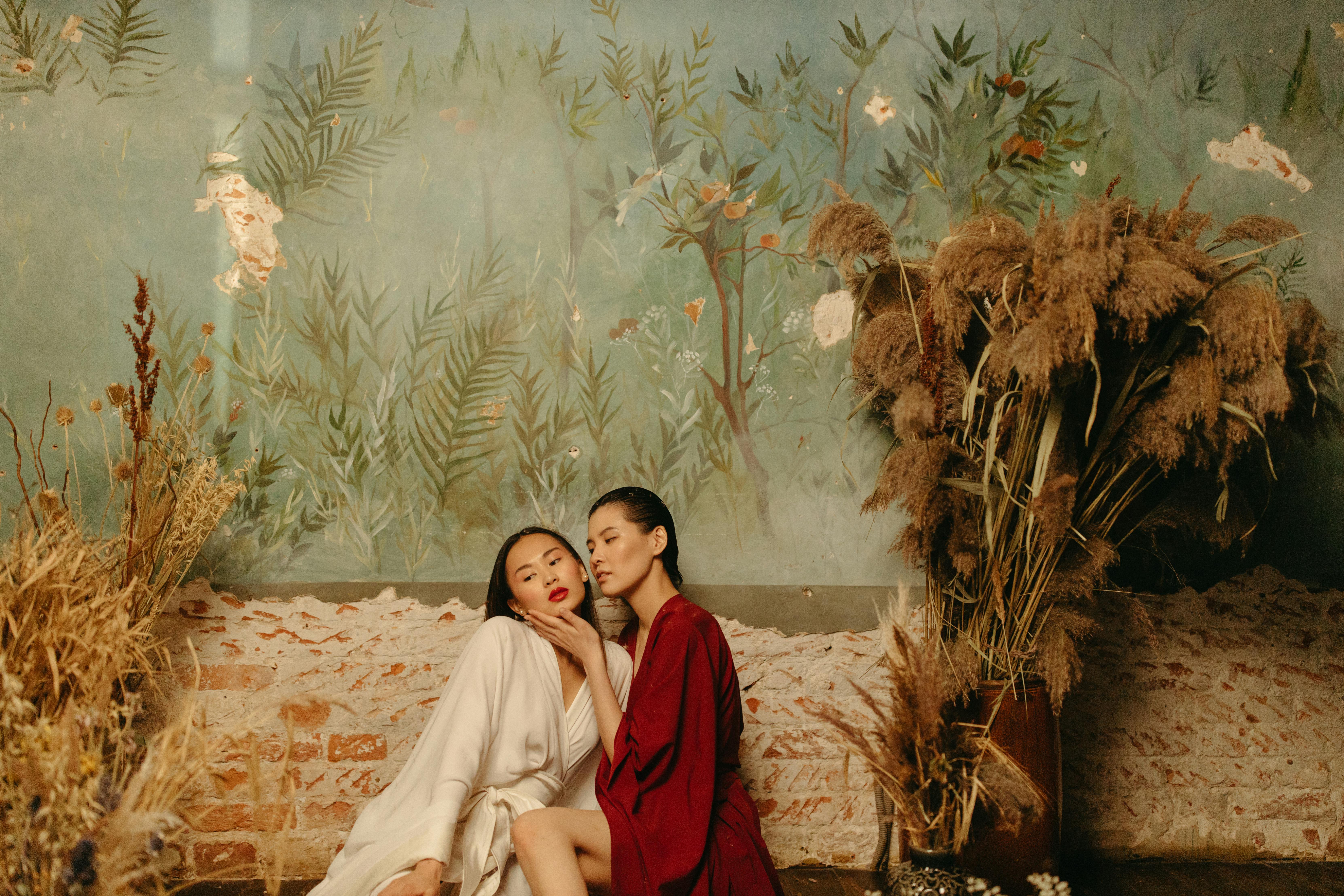 a couple sitting while wearing white and red kimono